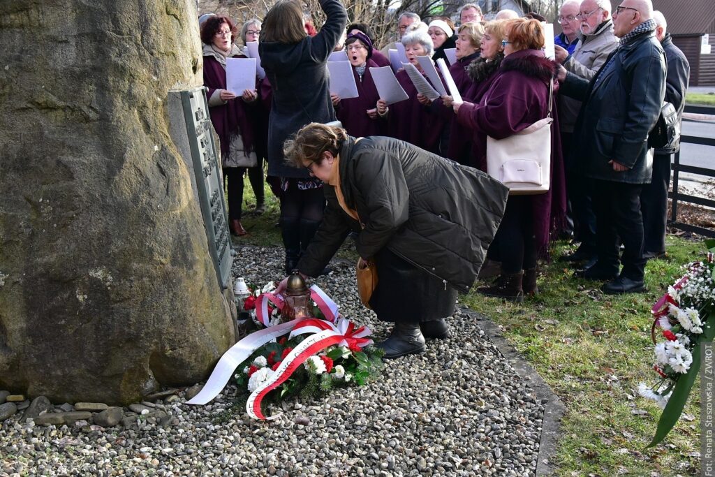 Danuta Branna składa kwiaty pod pomnikiem ofiar 2 wojny światowej w Nawsiu.